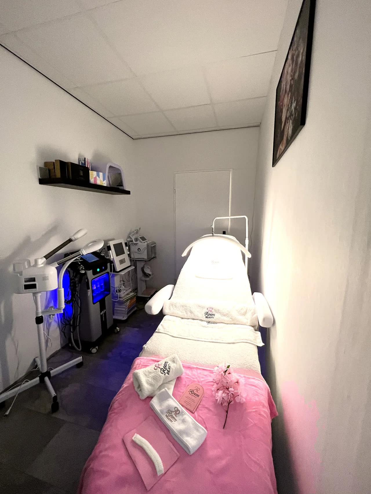 Behandelkamer van Reem Beauty in Spijkenisse: witte behandelbank, professionele apparatuur en serene luxe uitstraling